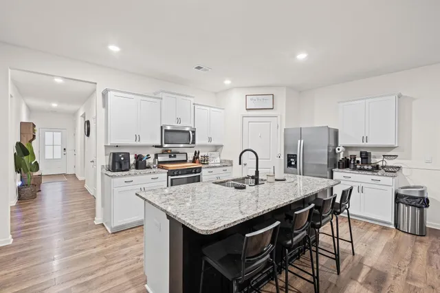 a kitchen with refrigerator cabinets dining table and chairs