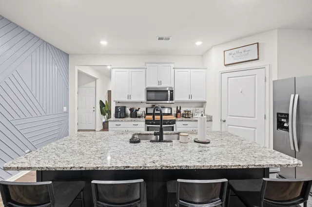 a kitchen with stainless steel appliances granite countertop a sink and refrigerator