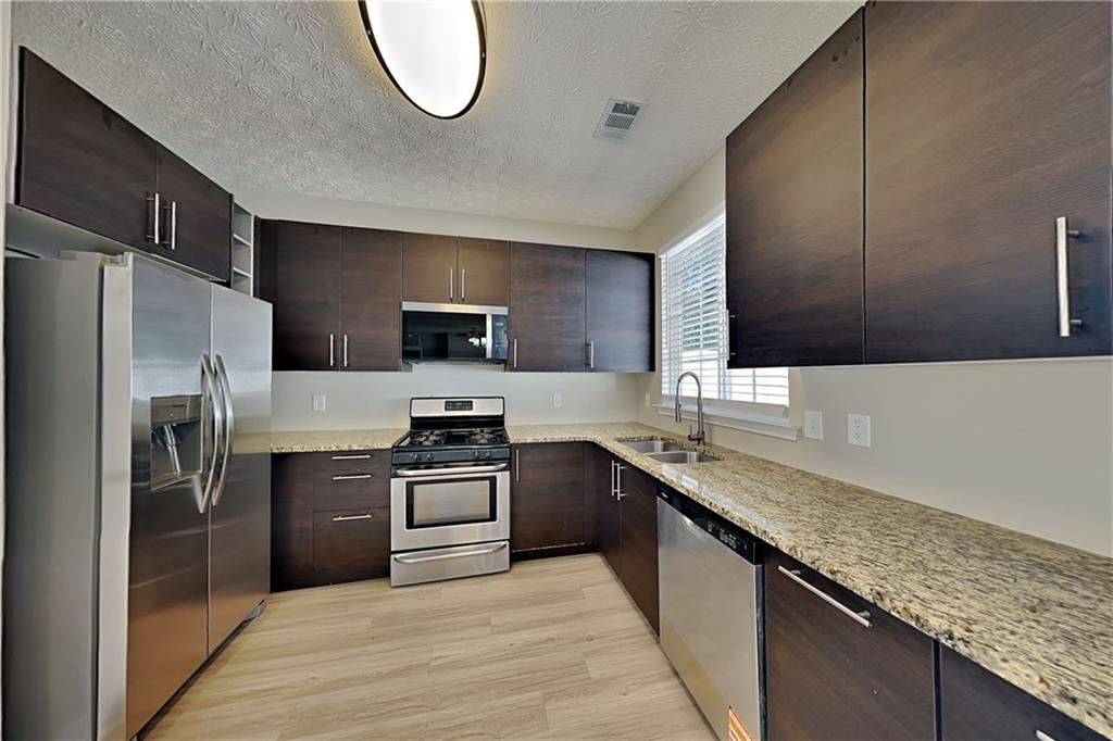 274 Windcroft Lane Northwest Acworth, GA 30101 - Photo 3 of 16 a kitchen with stainless steel appliances granite countertop a sink stove and refrigerator