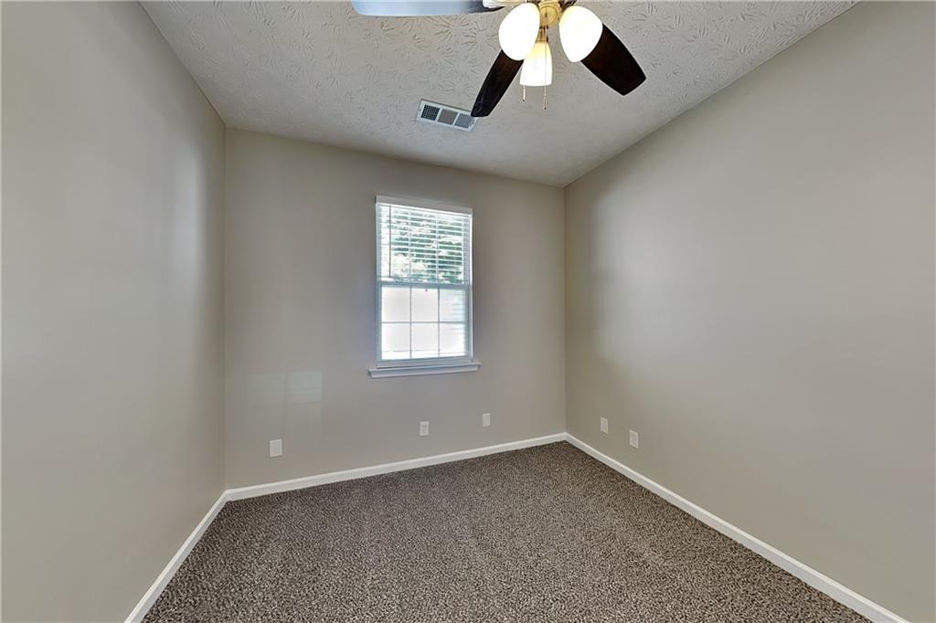 274 Windcroft Lane Northwest Acworth, GA 30101 - Photo 9 of 16 an empty room with a chandelier fan and windows