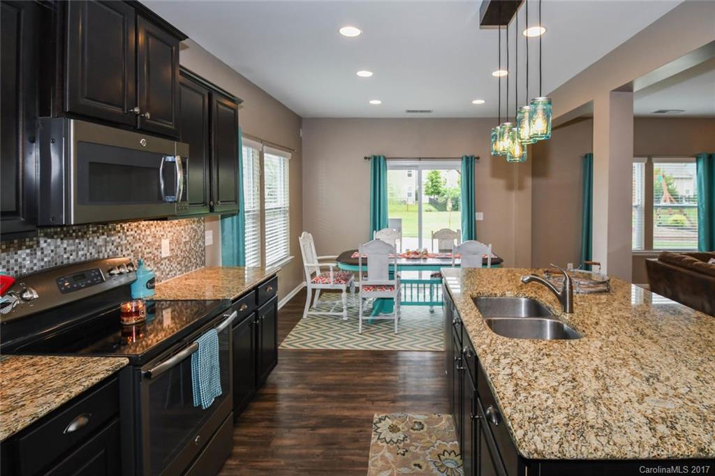 79457 Ridgehaven Road Lancaster, SC 29720 - Photo 5 of 24 a kitchen with stainless steel appliances granite countertop wooden cabinets a stove top oven a sink and dishwasher