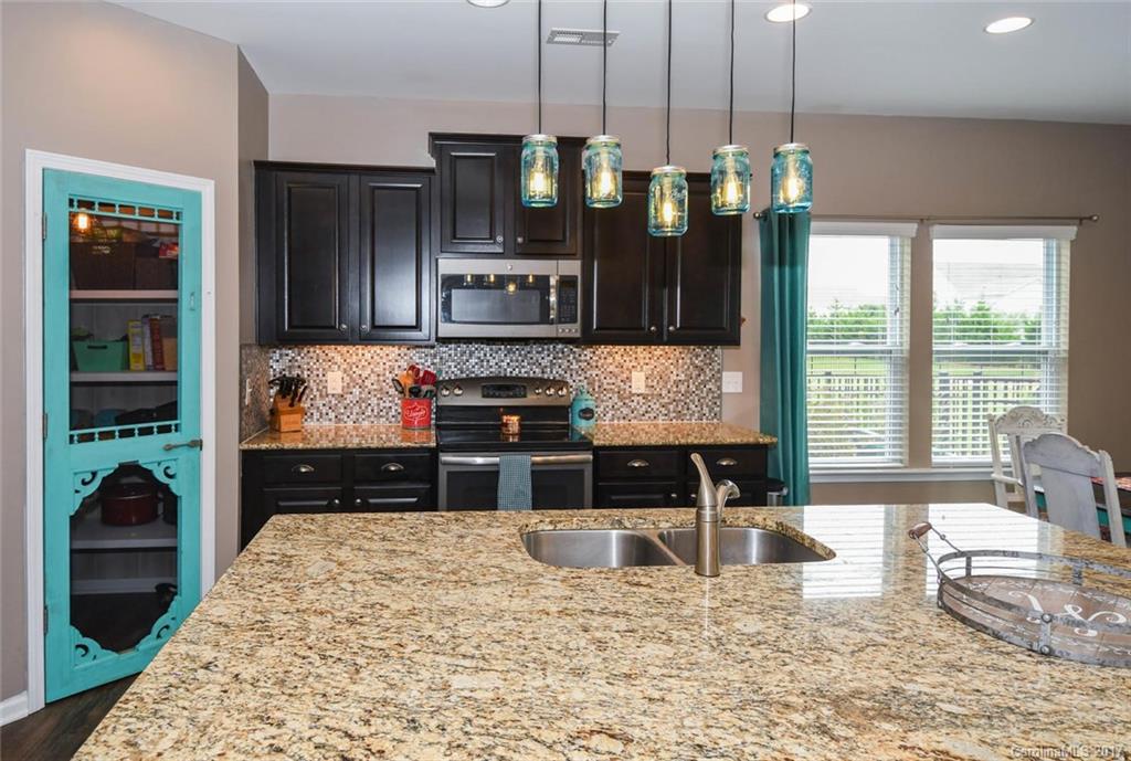 79457 Ridgehaven Road Lancaster, SC 29720 - Photo 6 of 24 a kitchen with stainless steel appliances granite countertop a stove top oven a sink and cabinets