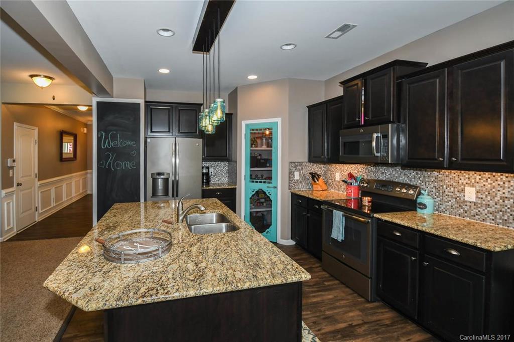 79457 Ridgehaven Road Lancaster, SC 29720 - Photo 7 of 24 a kitchen with stainless steel appliances granite countertop sink stove refrigerator and cabinets