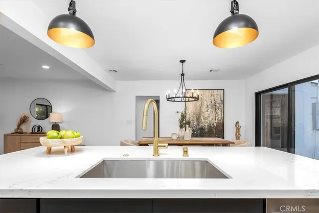 a kitchen with a sink and a chandelier