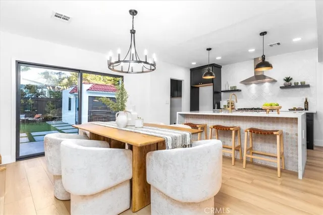 a dining room with furniture a chandelier and wooden floor