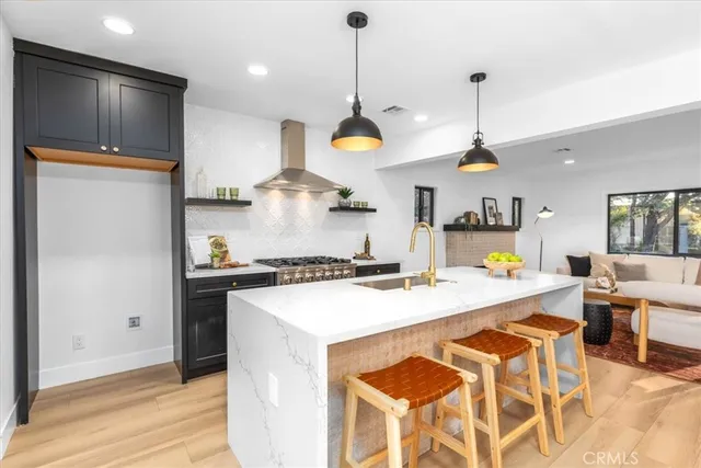a kitchen that has a lot of cabinets in it and wooden floors