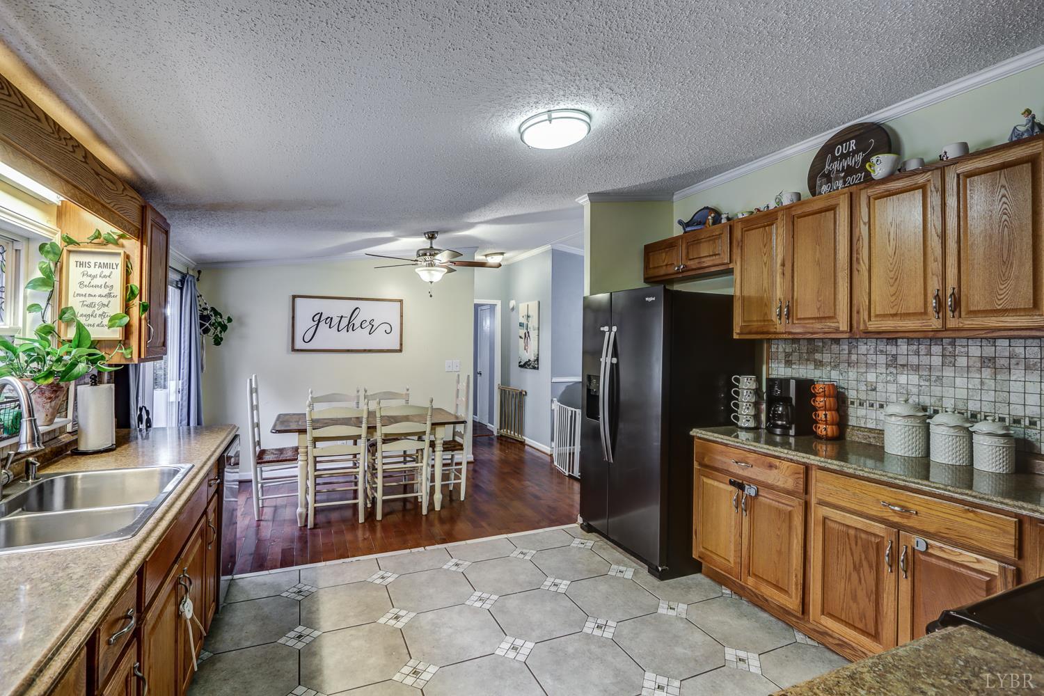 2019 Country Club Road Hurt, VA 24563 - Photo 7 of 39 a kitchen with stainless steel appliances granite countertop a refrigerator a sink dishwasher a dining table and chairs with wooden floor