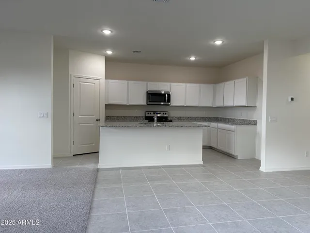 a kitchen with stainless steel appliances granite countertop a stove a sink and a refrigerator