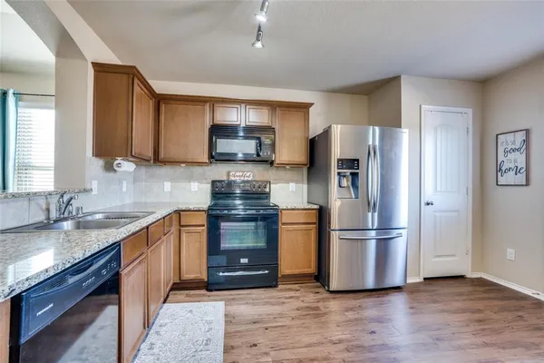 a kitchen with granite countertop a refrigerator stove and sink