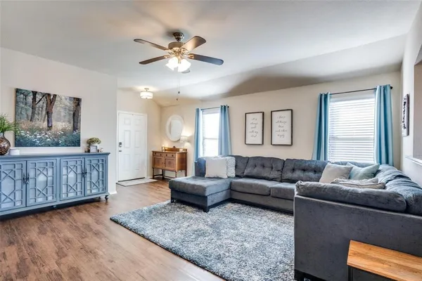 a living room with furniture and wooden floor