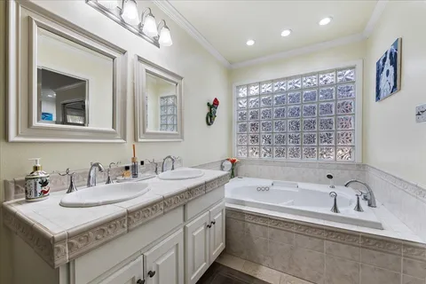a bathroom with 2 sink tub and a mirror