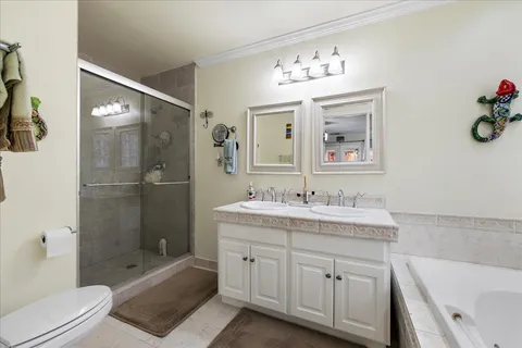 a bathroom with a toilet a sink a glass door a shower and a mirror