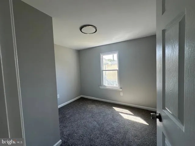 an empty room with closet and windows