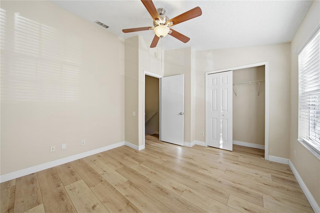 8530 Hunters Key Circle Tampa, FL 33647 - Photo 14 of 18 an empty room with wooden floor ceiling fan and windows