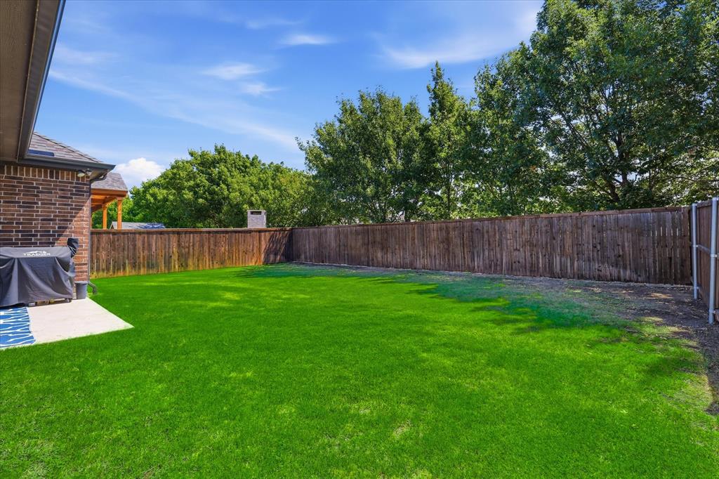 2908 Winding Ridge Court Oak Point, TX 75068 - Photo 30 of 38 Expansive backyard featuring a lush lawn, a privacy fence, and a concrete patio
