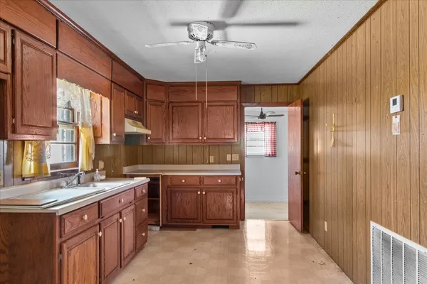 an empty room with fan and windows