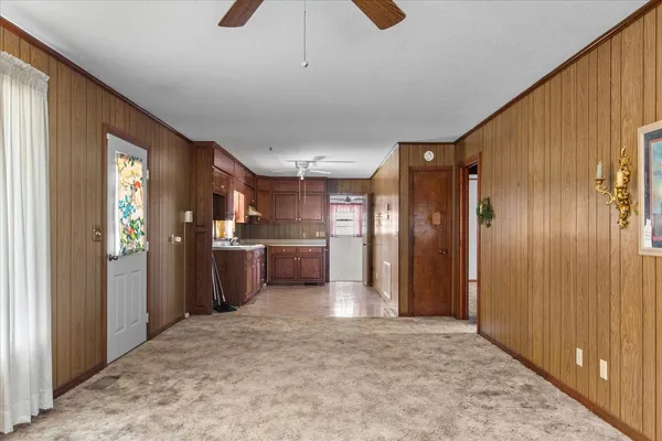 an empty room with windows and fan