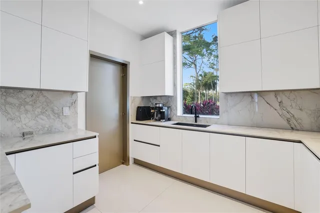a kitchen with stainless steel appliances granite countertop a sink and a stove next to a window