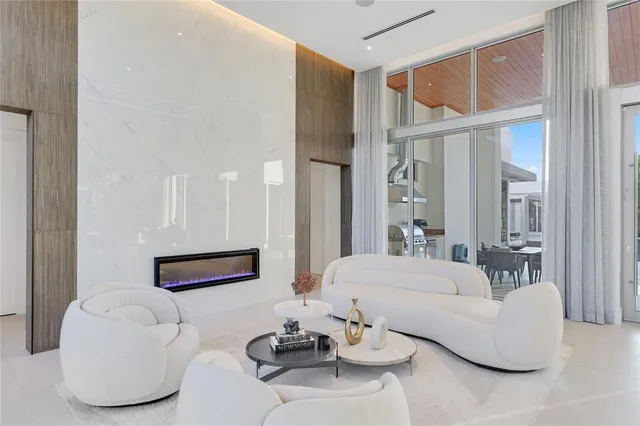 a living room with furniture kitchen view and a large window