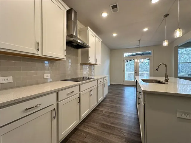 a large kitchen with cabinets wooden floor and stainless steel appliances