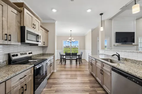 a kitchen with stainless steel appliances granite countertop a sink stove and microwave