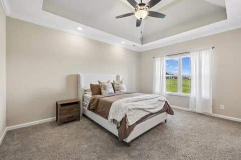 a bed sitting in a spacious bedroom next to a window