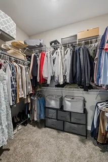 a view of walk in closet with clothes