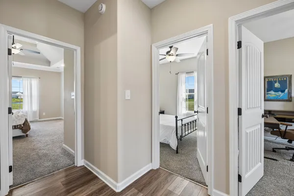 a view of a hallway with wooden floor and a living room