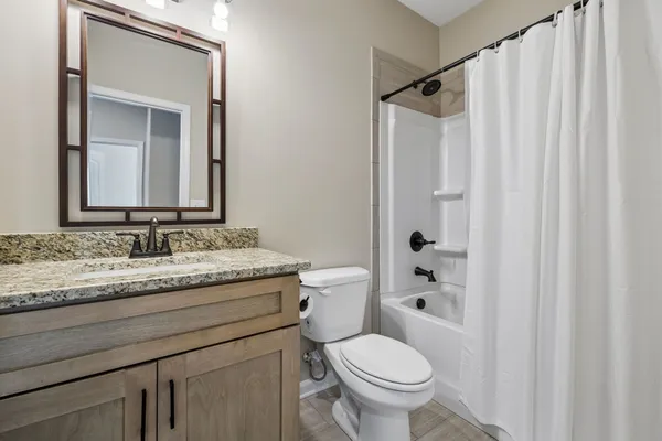 a bathroom with a granite countertop sink toilet and shower