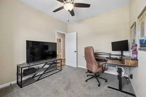 a view of a workspace with furniture and a flat screen tv