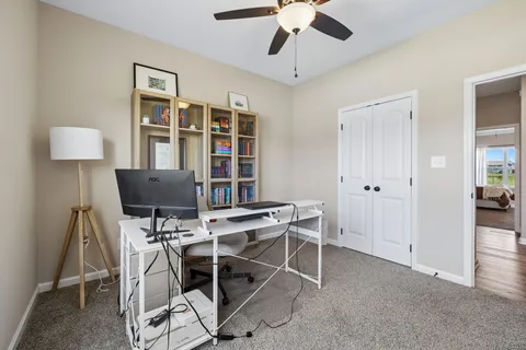 a view of a workspace with furniture and a window