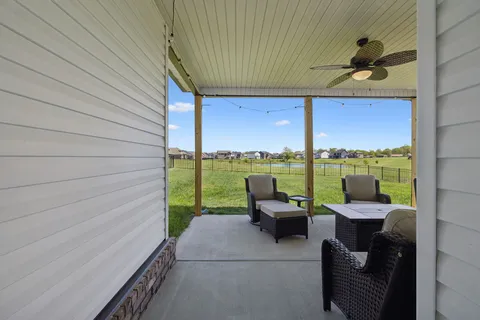 a view of a patio with chairs and a garden