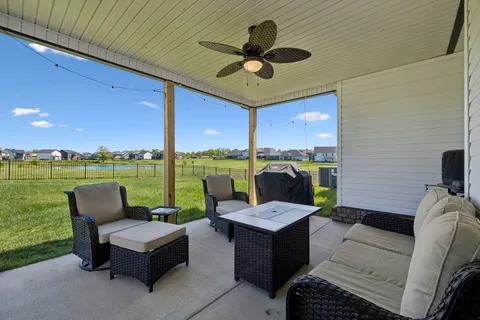 a living room with patio furniture and a garden