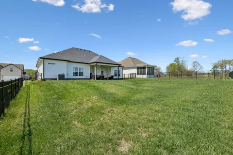 a view of a house with a big yard and large trees