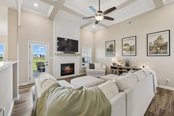 a living room with furniture a flat screen tv and a fireplace