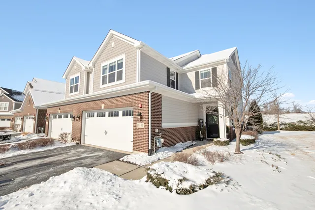 a front view of a house with a yard covered in snow