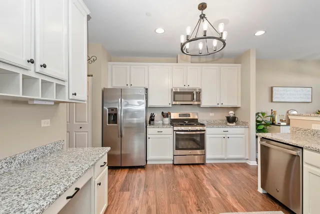 a kitchen with white cabinets and stainless steel appliances