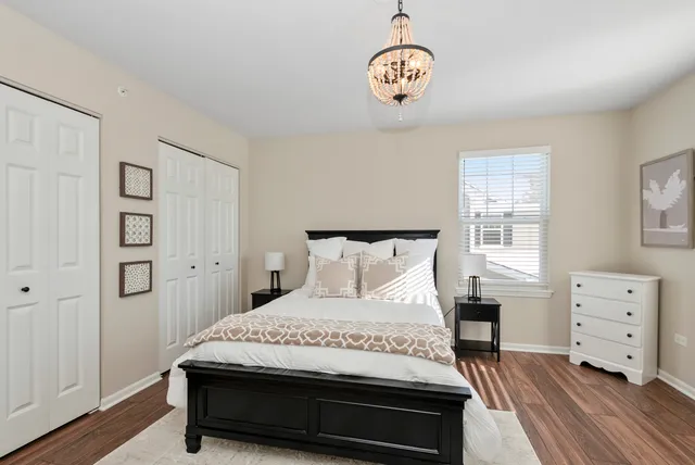 a bedroom with a bed and a lamp on dresser