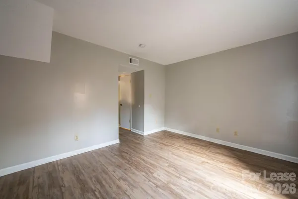 a view of an empty room with wooden floor