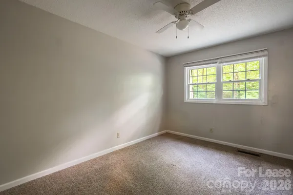 an empty room with a window and a ceiling fan