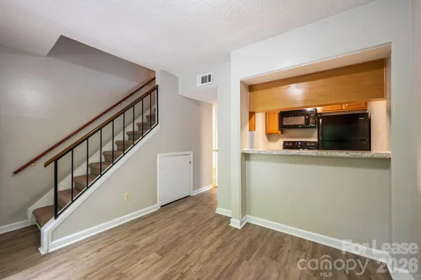 a living room with wooden floor and a flat screen tv