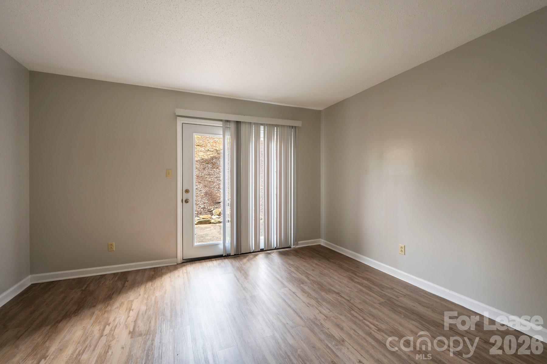 135 Ribet Avenue Southwest, Unit C12 Valdese, NC 28690 - Photo 9 of 19 an empty room with wooden floor and windows