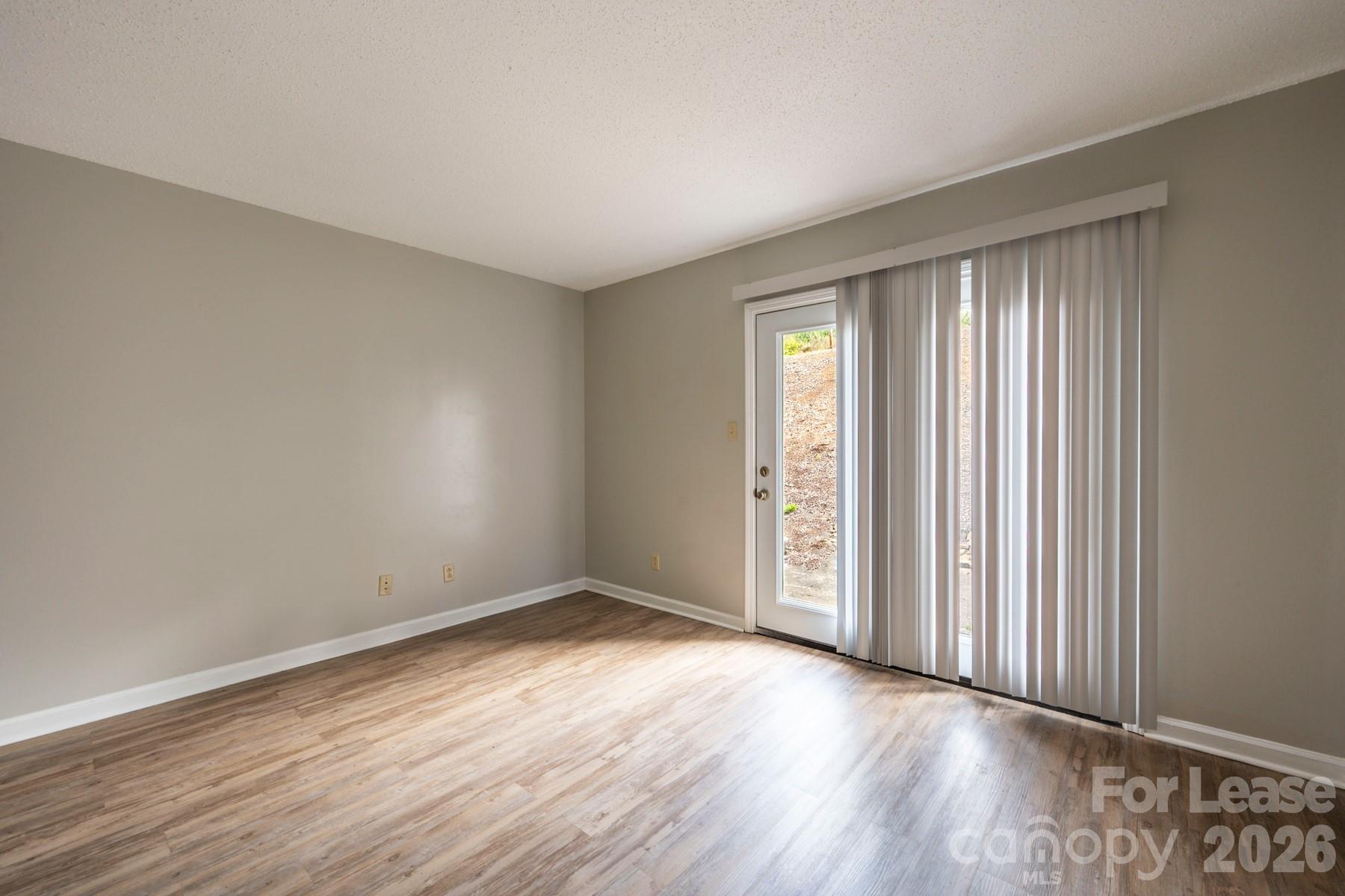 135 Ribet Avenue Southwest, Unit C12 Valdese, NC 28690 - Photo 10 of 19 an empty room with wooden floor and windows
