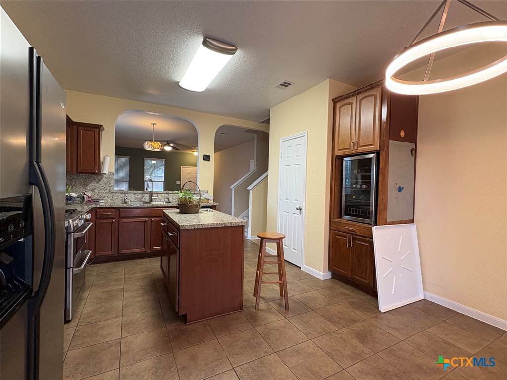 102 Wisteria Way San Marcos, TX 78666 - Photo 11 of 30 a large kitchen with stainless steel appliances kitchen island granite countertop a refrigerator and a sink