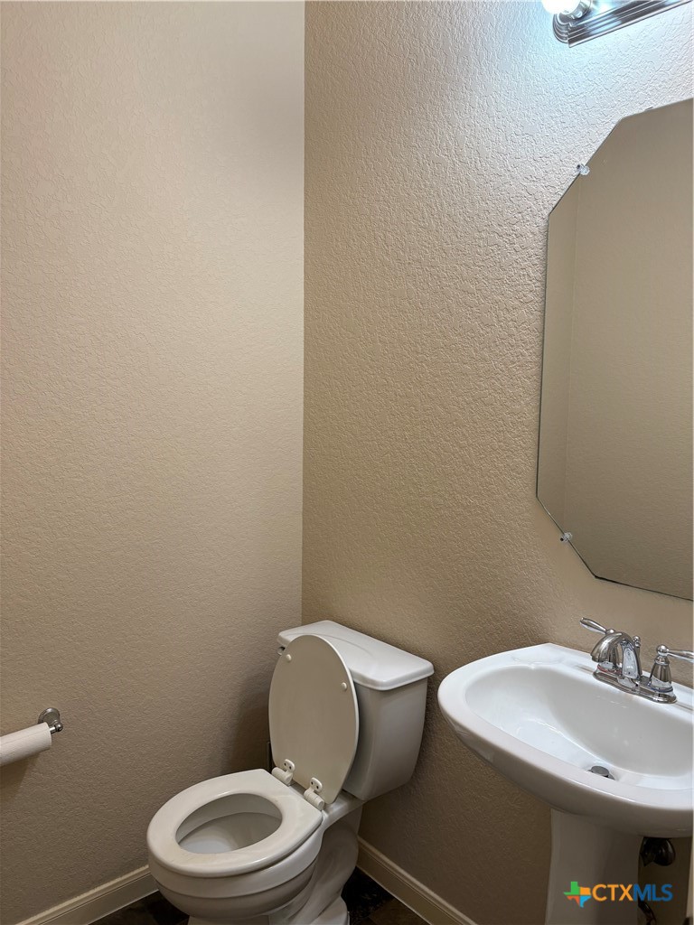 102 Wisteria Way San Marcos, TX 78666 - Photo 15 of 30 a white toilet sitting next to a bathroom sink