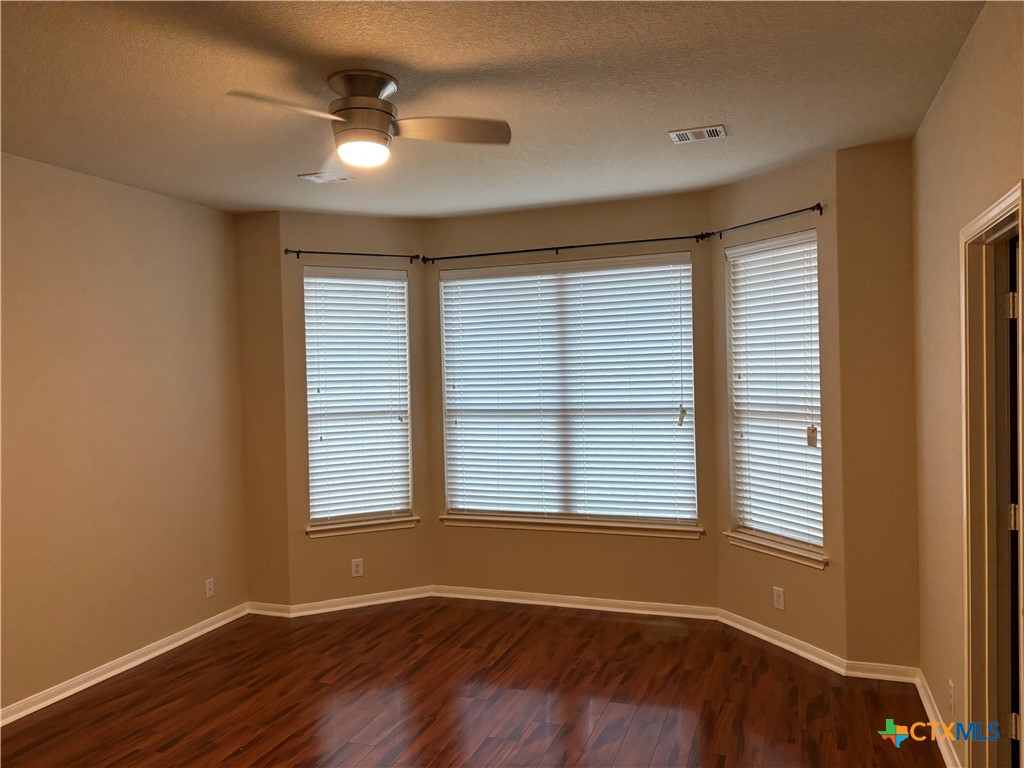 102 Wisteria Way San Marcos, TX 78666 - Photo 16 of 30 a view of an empty room with wooden floor and a window