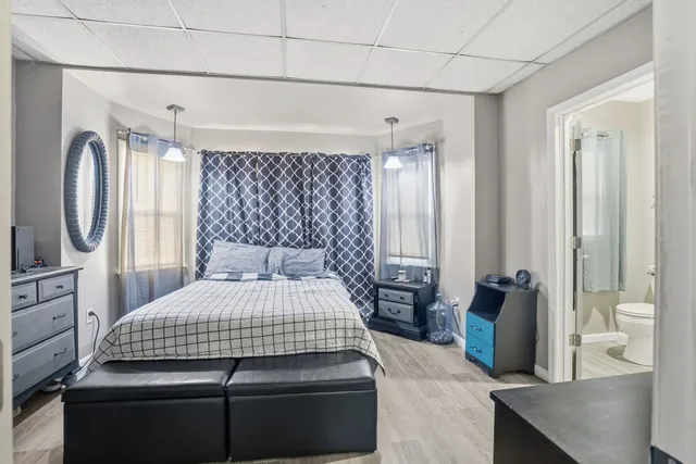 a bedroom with a large bed and a chandelier