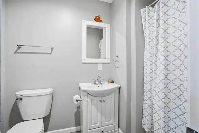 a bathroom with a sink toilet and mirror