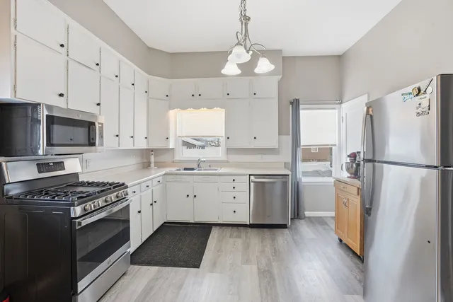 a kitchen with granite countertop a refrigerator stove top oven and sink