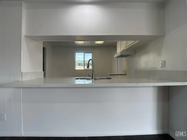 a view of a kitchen with kitchen island a sink and wooden floor
